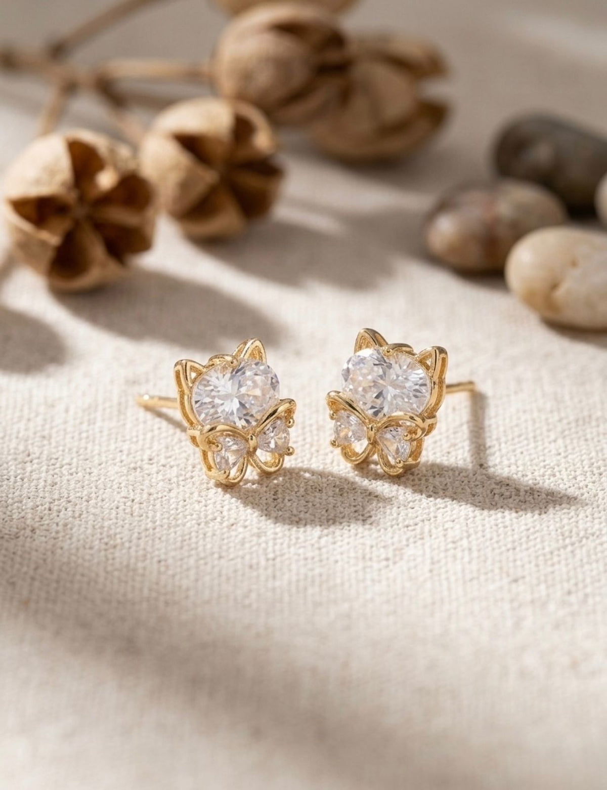 Gold butterfly stud earrings set with a solitaire-cut crystal