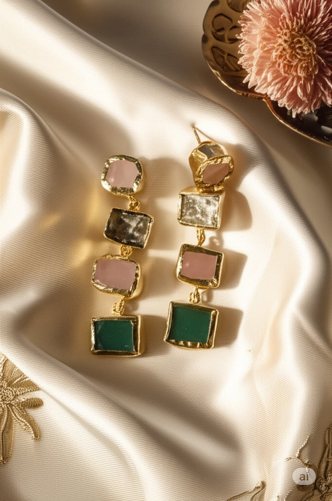 Brass earrings with colorful gemstones on a satin surface